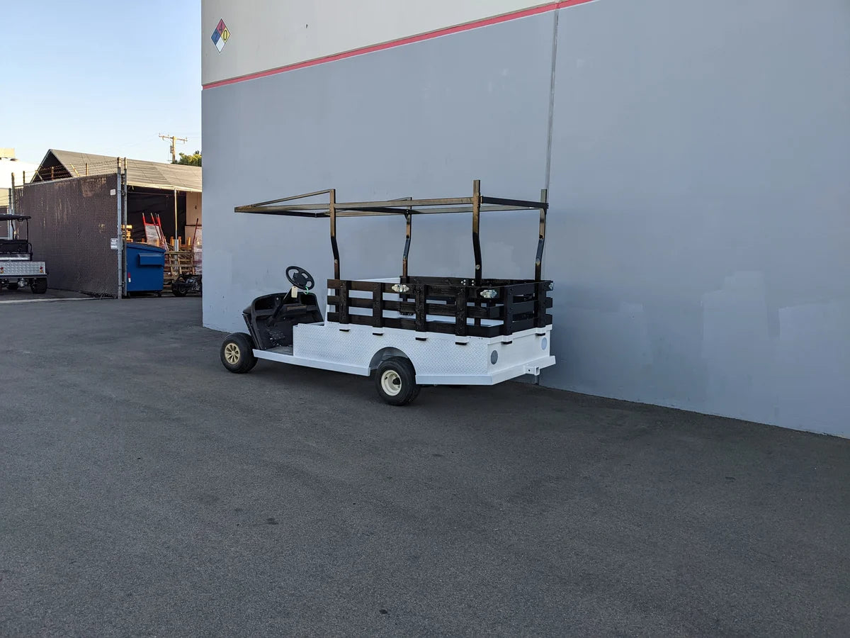 Golf cart with custom fabricated white flatbed featuring STAKE-SIDES-44X72X18 Flatbed Golf Cart Stake Sides for securing cargo on specialty golf cart beds.