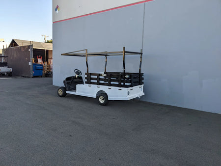 Golf cart with custom fabricated white flatbed featuring STAKE-SIDES-44X72X18 Flatbed Golf Cart Stake Sides for securing cargo on specialty golf cart beds.