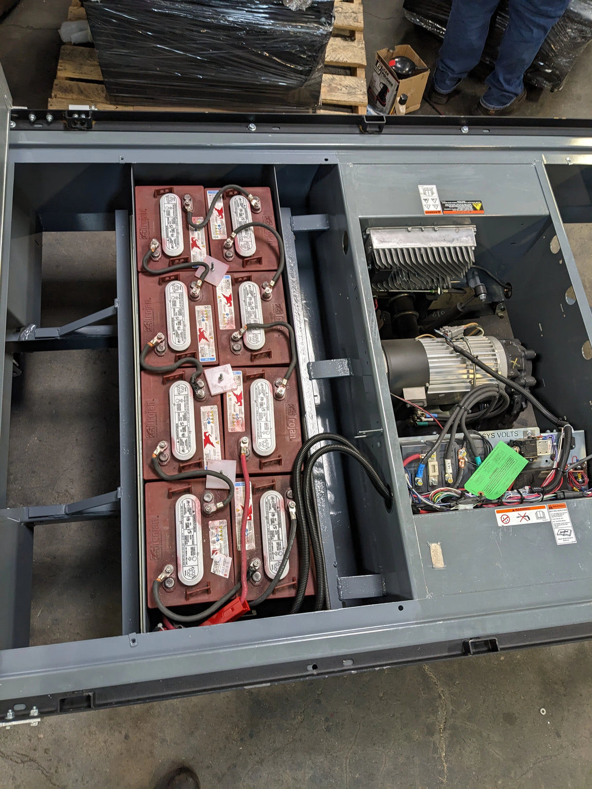 Open battery compartment showing multiple connected batteries and electrical components installed in the BIGFOOT XL BATTERY SLIDE-OUT RETROFIT FOR TAYLOR-DUNN BIGFOOT XL for utility and cart haulers.