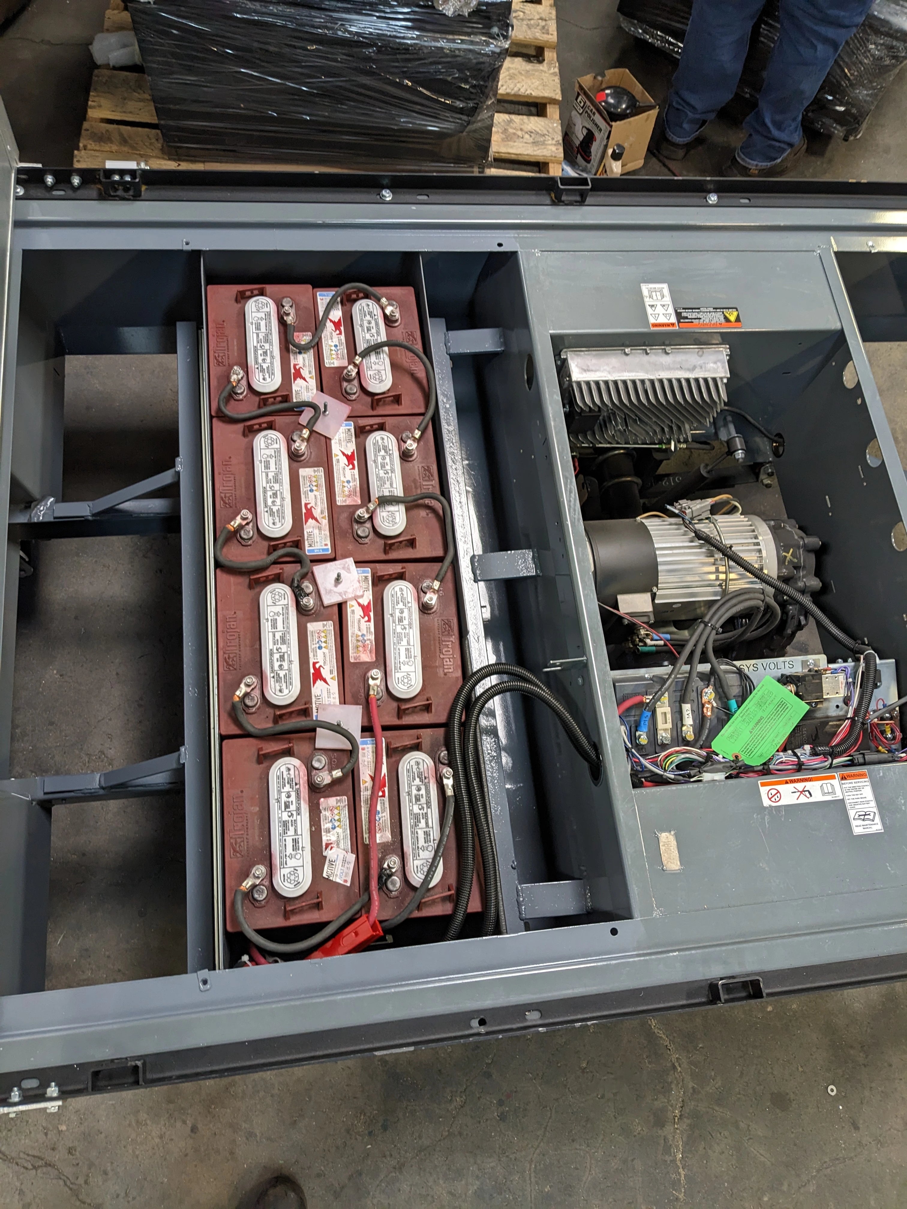 Open battery compartment showing multiple connected batteries and electrical components installed in the BIGFOOT XL BATTERY SLIDE-OUT RETROFIT FOR TAYLOR-DUNN BIGFOOT XL for utility and cart haulers.