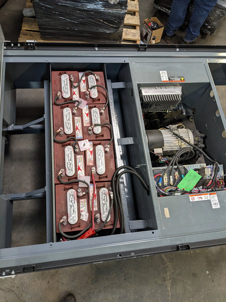 Open battery compartment showing multiple connected batteries and electrical components installed in the BIGFOOT XL BATTERY SLIDE-OUT RETROFIT FOR TAYLOR-DUNN BIGFOOT XL for utility and cart haulers.