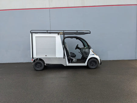 White golf cart with a custom fabrication GEM-ELXD-53X120-TLR Top Mount Ladder Rack for outside mount on a GEM ELXD, featuring a roof rack and enclosed cargo area.