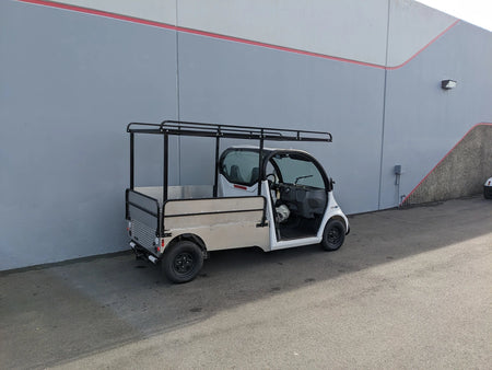 Custom fabricated DROP RAILS GEM ELXD SOL SOLID SIDE RAILS FOR GEM ELXD installed on a golf cart flatbed for secure cargo transport and utility use.