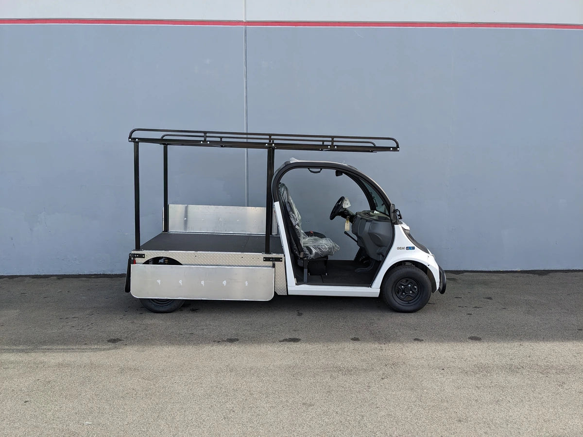 White utility golf cart with flatbed and black metal frame featuring DROP RAILS GEM ELXD SOL SOLID SIDE RAILS FOR GEM ELXD custom fabrication for golf carts