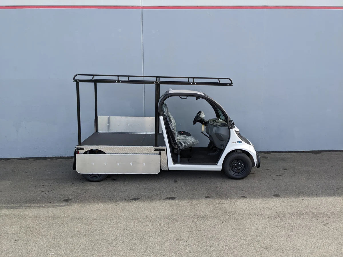 Small white utility vehicle with a flatbed and a black GEM-ELXD-53X120-IN-TLR Top Mount Ladder Rack for mounting inside the bed of a GEM ELXD, custom fabrication for golf carts designed for cargo and utility use.
