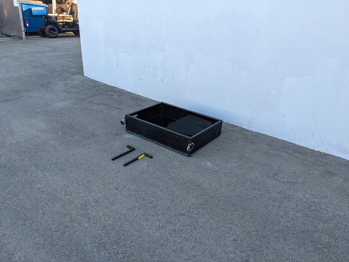 Black heavy-duty metal utility box with open compartments placed on pavement alongside tools, showcasing the EVO-CLASSIC-UTIL31 EVOLUTION CLASSIC HEAVY-DUTY UTILITY BOX designed for custom fabrication for golf carts.