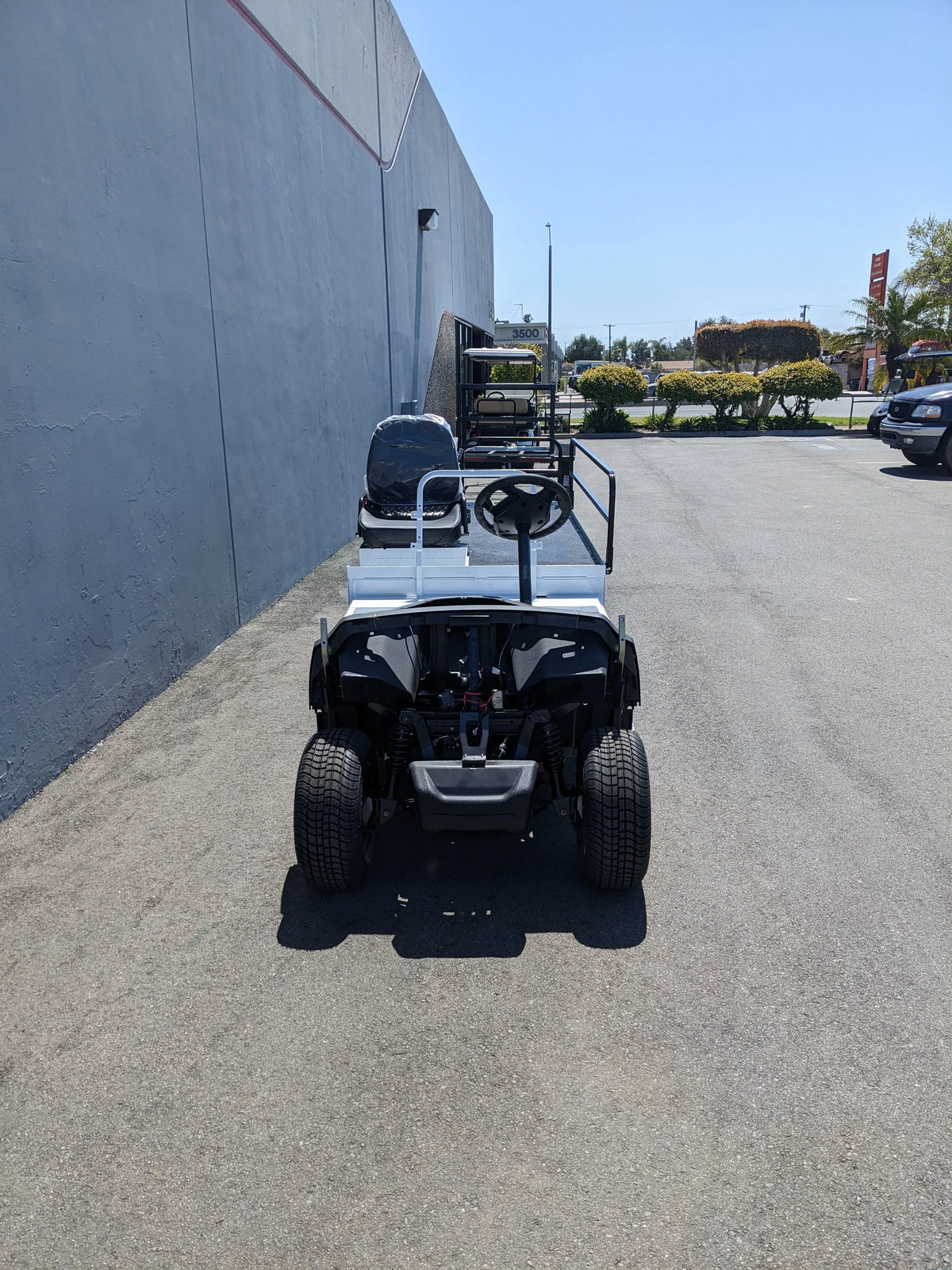 Rear view of YAM-AMB-2SEAT-ST-FLAT-84 2Seat Ambulance Conversion on Yamaha Flatbed showing custom fabrication for golf carts with a white flatbed and seating for two.
