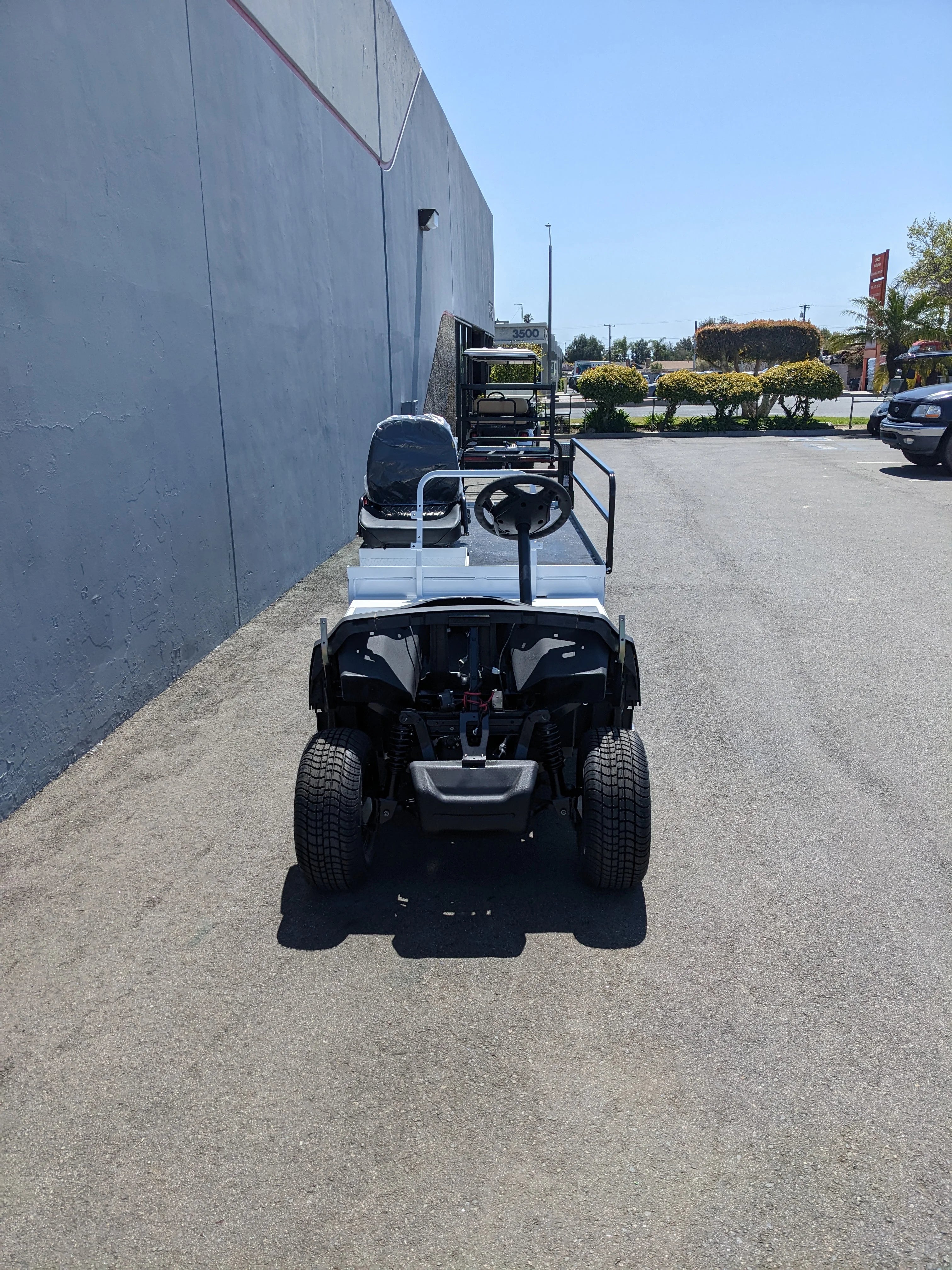 Rear view of YAM-AMB-2SEAT-ST-FLAT-84 2Seat Ambulance Conversion on Yamaha Flatbed showing custom fabrication for golf carts with a white flatbed and seating for two.