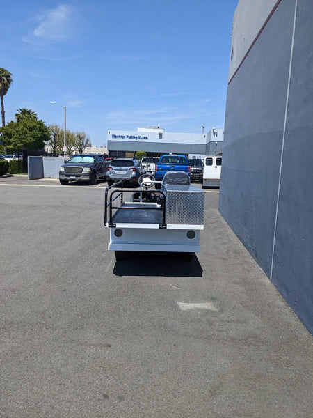 YAM-AMB-2SEAT-ST-FLAT-84 2Seat Ambulance Conversion on Yamaha Flatbed shown outdoors on pavement with custom fabrication for golf carts, featuring flatbed and utility box components.