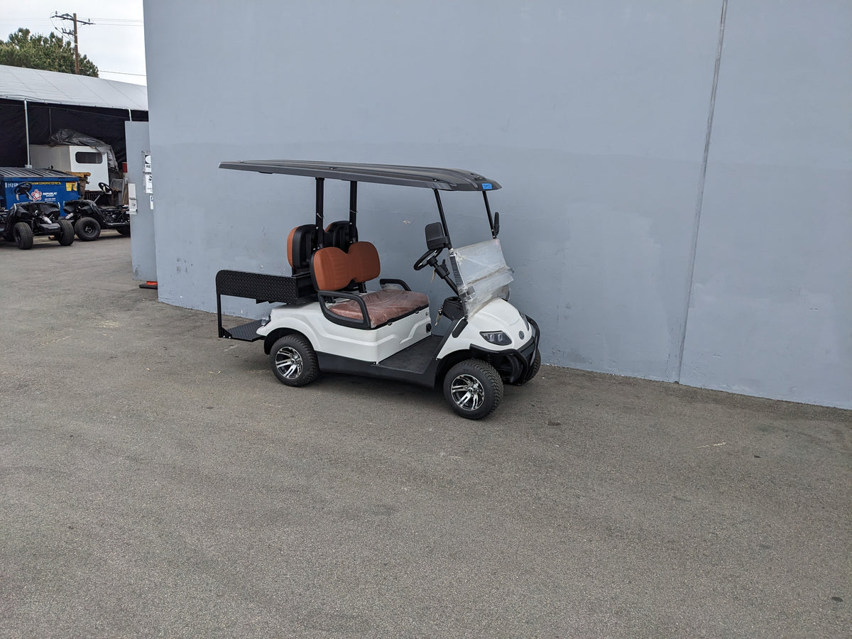 White golf cart equipped with CRUISE-C40-SB-COMBO CRUISE CAR/ICON C40 HEAVY-DUTY SEAT BACK COMBINATION SEAT/DECK KIT featuring brown cushioned seats and a black roof, custom fabrication for golf carts.