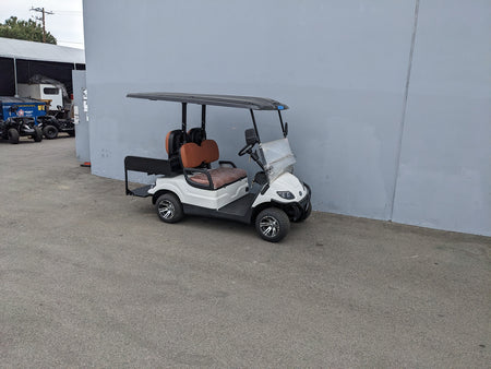 White golf cart equipped with CRUISE-C40-SB-COMBO CRUISE CAR/ICON C40 HEAVY-DUTY SEAT BACK COMBINATION SEAT/DECK KIT featuring brown cushioned seats and a black roof, custom fabrication for golf carts.