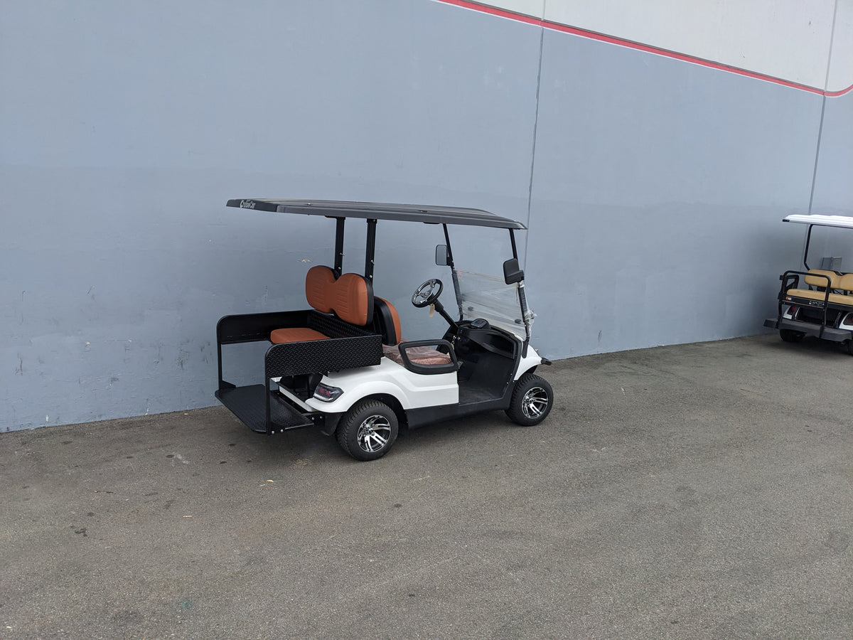 White golf cart equipped with CRUISE-C40-SB-COMBO CRUISE CAR/ICON C40 HEAVY-DUTY SEAT BACK COMBINATION SEAT/DECK KIT featuring orange seats and custom fabrication for golf carts.