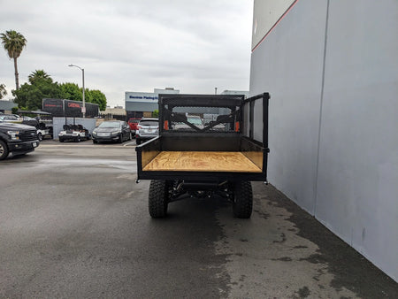 Rear view of FB-POL-PROXD-54X76X11-STAKE-OCB POLARIS STAKEBED RETROFIT featuring custom fabrication for golf carts with a flatbed cargo area and steel mesh sides.