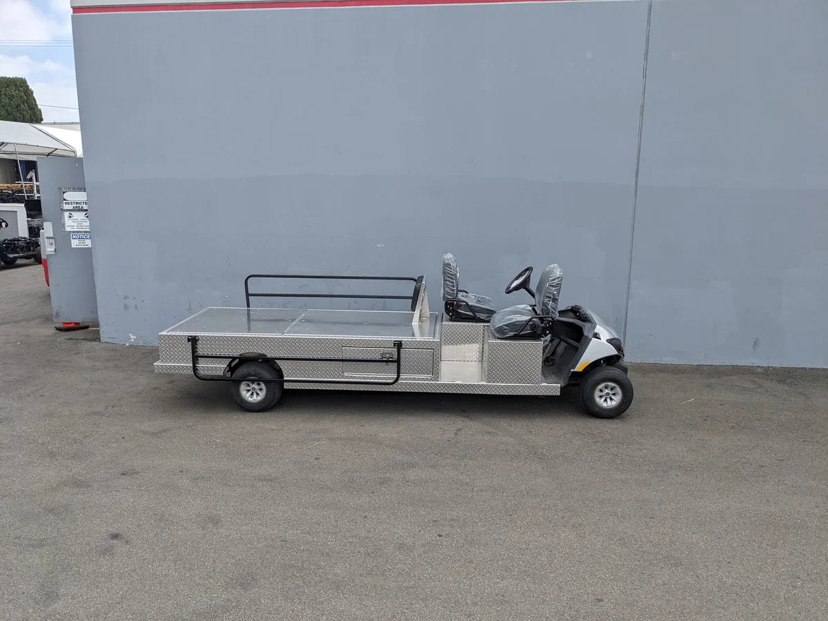 White utility cart with metal flatbed and rear seating, designed for specialized use, custom fabrication for golf carts, YAM-AMB-2SEAT-REAREMT-96X23 AMBULANCE CART.
