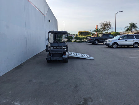 CUSH-WHEELCHAIR-TRANSPORT CUSHMAN GOLF CART CONVERSIONS FOR WHEELCHAIR PASSENGER showing a custom fabrication golf cart with an extended ramp for easy wheelchair access in a parking lot.