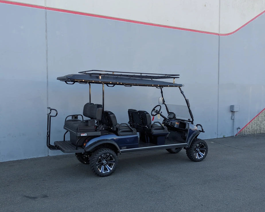 Golf cart equipped with EVO-CLASSIC2-6PASS-84RR3 EVOLUTION CLASSIC 6 PASSENGER ROOF RACK, custom fabrication for golf carts, featuring a sturdy flatbed rack above six passenger seats.