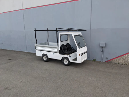White utility golf cart equipped with the TD-BIG-44X120-TLRI Top Mount Ladder Rack for mounting inside the bed of a Taylor Dunn Bigfoot, designed for custom fabrication of golf carts.