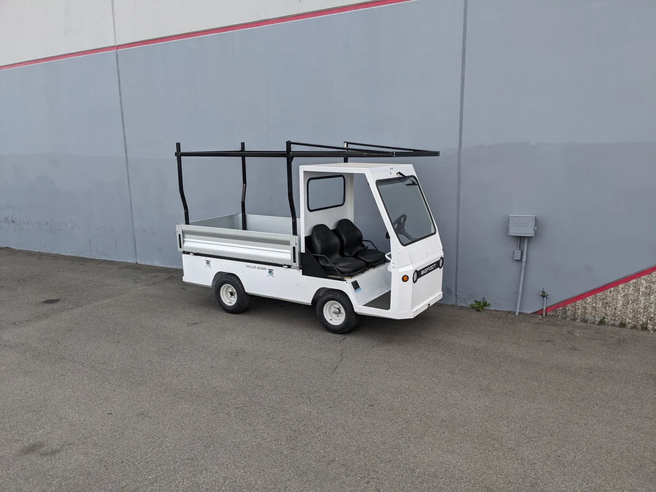 White utility golf cart equipped with the TD-BIG-44X120-TLRI Top Mount Ladder Rack for mounting inside the bed of a Taylor Dunn Bigfoot, designed for custom fabrication of golf carts.