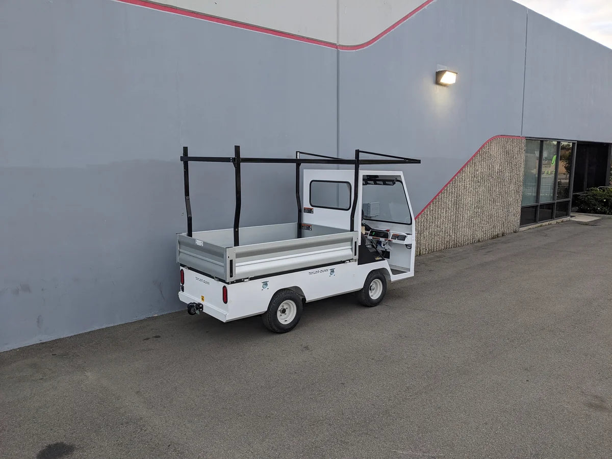 White golf cart equipped with a TD-BIG-44X120-TLRI Top Mount Ladder Rack for mounting inside the bed of a Taylor Dunn Bigfoot, designed for custom fabrication in golf cart cargo utility use.