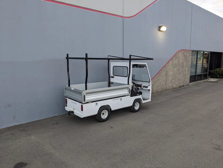 White golf cart equipped with a TD-BIG-44X120-TLRI Top Mount Ladder Rack for mounting inside the bed of a Taylor Dunn Bigfoot, designed for custom fabrication in golf cart cargo utility use.