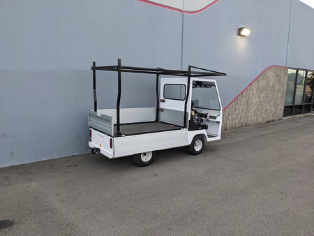 White utility golf cart with an installed TD-BIG-44X120-TLRI Top Mount Ladder Rack for mounting inside the bed of a Taylor Dunn Bigfoot, showcasing custom fabrication for golf carts.