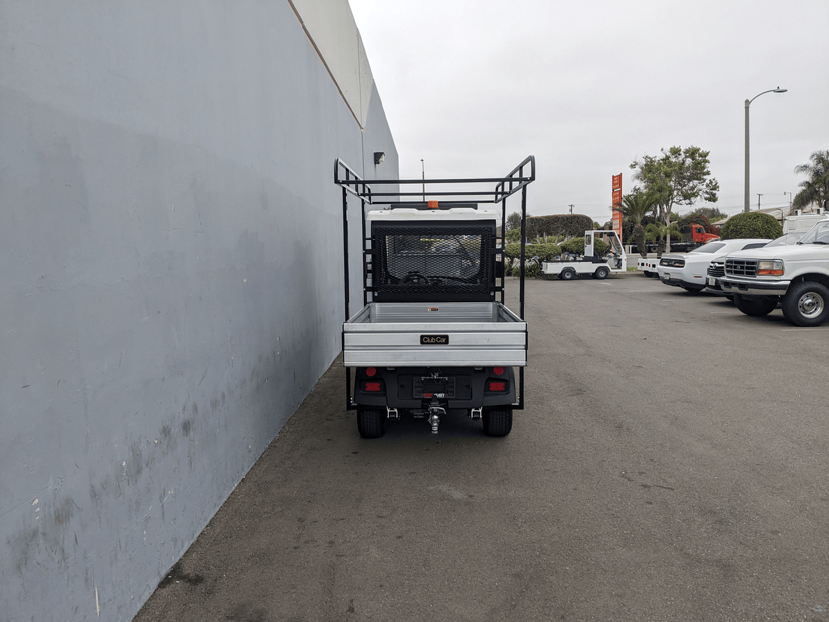 Rear view of a utility vehicle equipped with the CC-710-50X96-CHASSIS-TLRA-GUARD CLUB CAR 710 TOP LADDER RACK AND CAB GUARD, suitable for carrying ladders and cargo securely.