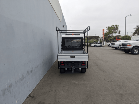 Rear view of a utility vehicle equipped with the CC-710-50X96-CHASSIS-TLRA-GUARD CLUB CAR 710 TOP LADDER RACK AND CAB GUARD, suitable for carrying ladders and cargo securely.
