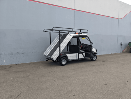Utility golf cart equipped with CC-710-50X96-CHASSIS-TLRA-GUARD CLUB CAR 710 TOP LADDER RACK AND CAB GUARD, featuring black metal frame and aluminum flatbed side panels.