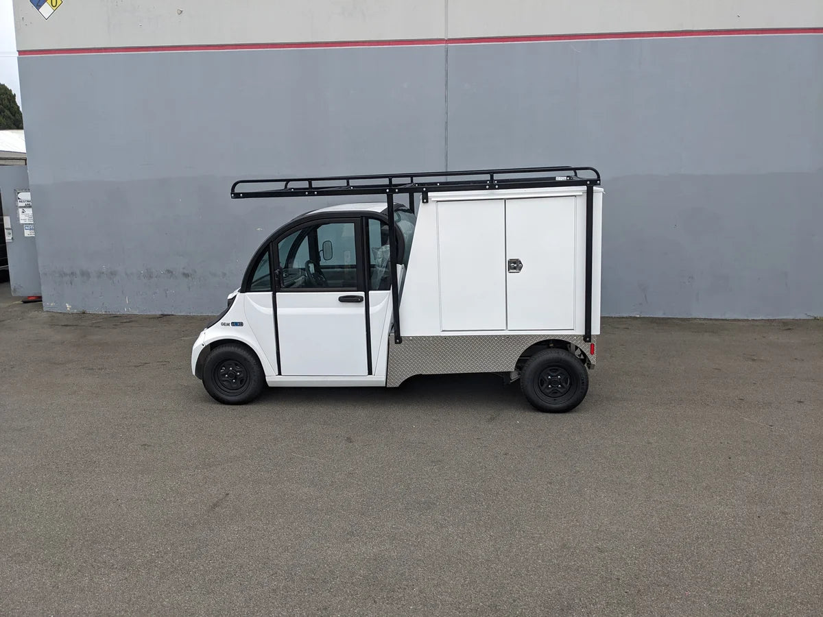 White utility golf cart equipped with a GEM-ELXD-53X120-TLR Top Mount Ladder Rack for outside mount on a GEM ELXD, featuring custom fabrication for golf carts and storage compartments.