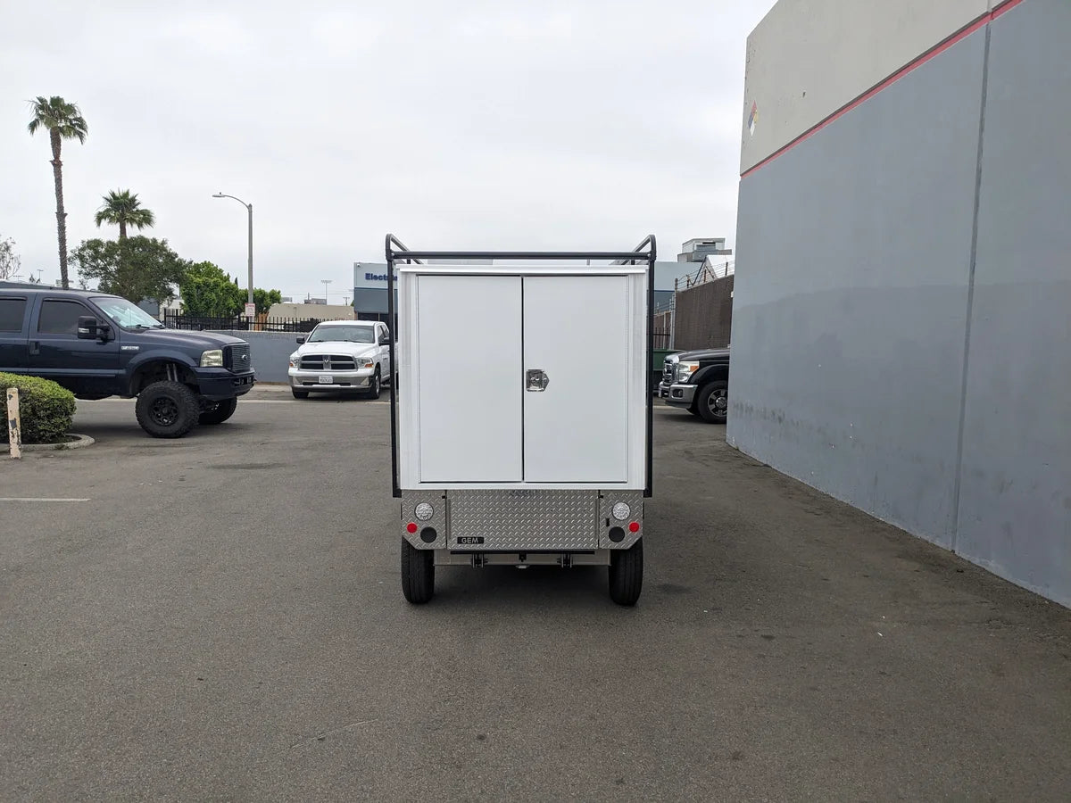 Rear view of a custom golf cart with GEM-ELXD-53X120-TLR Top Mount Ladder Rack for outside mount on a GEM ELXD, designed for carrying ladders and utility cargo.