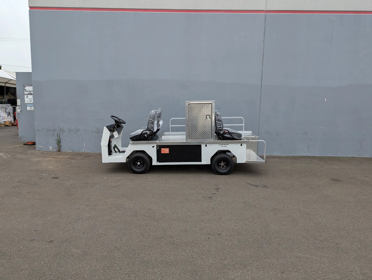 White flatbed cart with three-seat ambulance conversion and metal storage box, customized for Cushman Titan, designed for utility and specialty golf cart use.