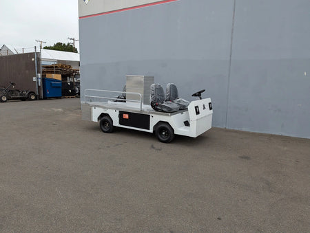 CUSH-TITAN-3SEAT-84X23 Ambulance Conversion for Cushman Titan parked outside a warehouse, showcasing custom fabrication for golf carts with utility and cargo features.