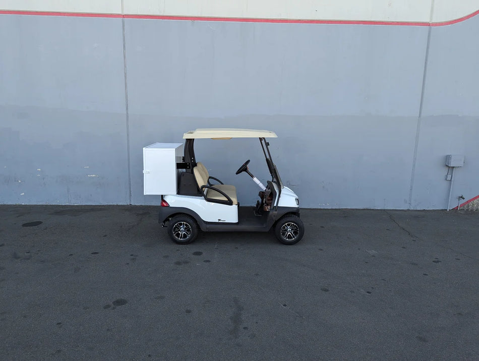 White golf cart equipped with a TB-36X18X28-FH BED MOUNT TOOLBOX WITH HINGED DOOR installed on the back, showcasing custom fabrication for golf carts utility and cargo storage.