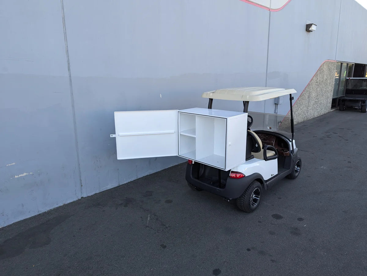 White TB-36X18X28-FH BED MOUNT TOOLBOX WITH HINGED DOOR installed on the back of a golf cart, showcasing custom fabrication for golf carts with spacious interior storage compartments.