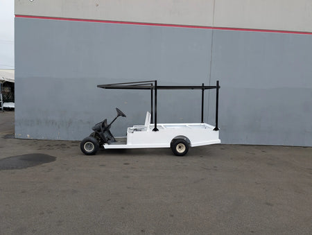 White custom flatbed golf cart with black FB-45X120-TLR FLATBED TOP LADDER RACK, 45″ X 120″ WITH REMOVABLE REAR CROSS BAR installed, designed for carrying ladders and cargo.