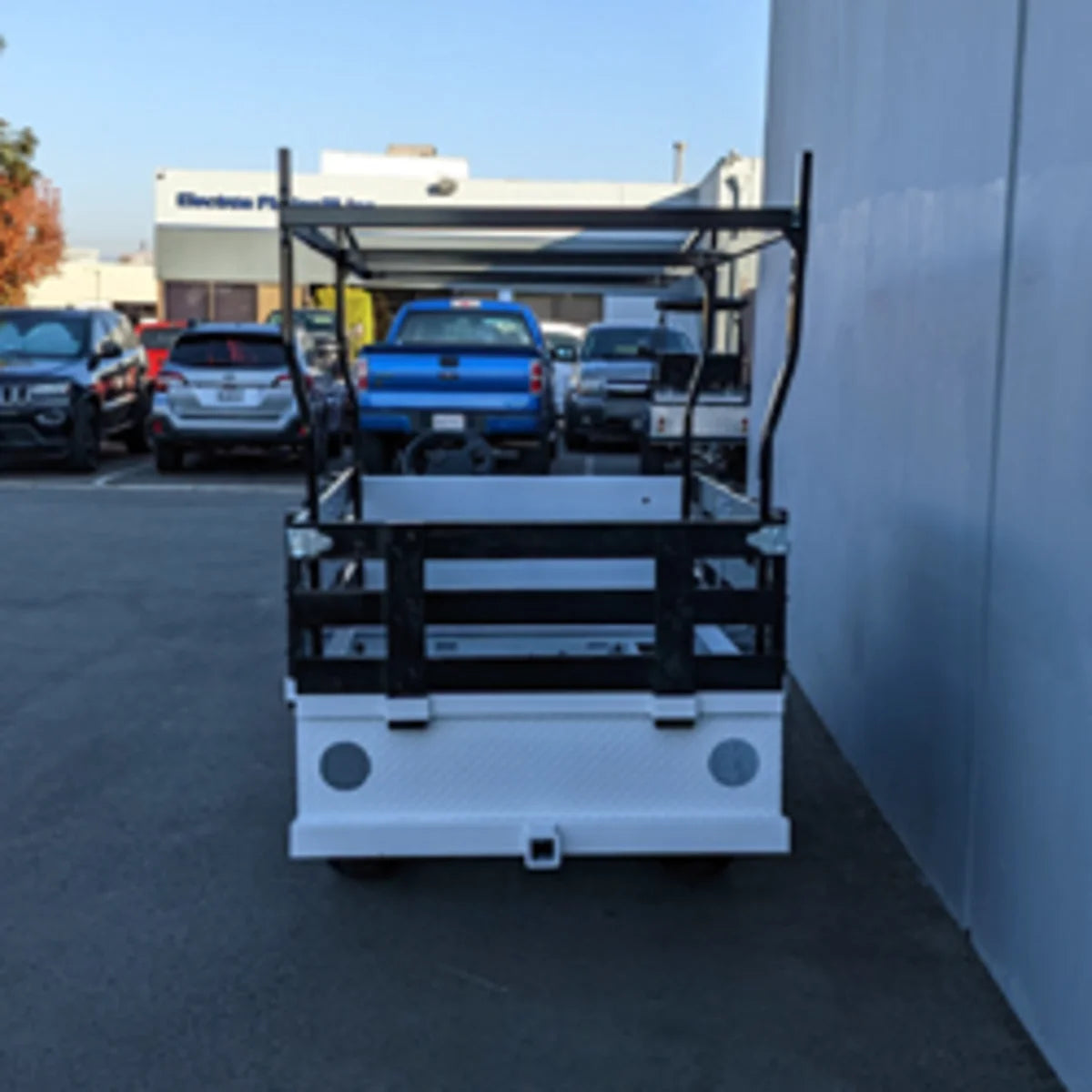 Black metal stake sides mounted on a white flatbed utility golf cart, showcasing the STAKE-SIDES-44X72X18 Flatbed Golf Cart Stake Sides with custom fabrication for golf carts.
